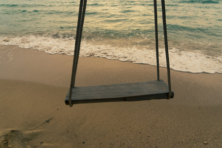 Swing at the beach with lighting sunset background. Twilight background.の写真素材