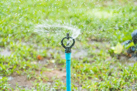 Automatic lawn water sprinkler in urban park. Water saving concept.の写真素材