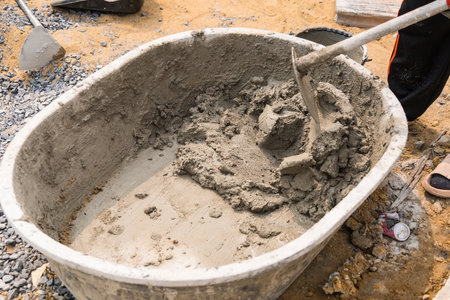 Mix cement sand and stones with hoe leak inside big bucket on floor backgroundの写真素材