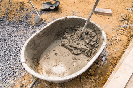 Mix cement sand and stones with hoe leak inside big bucket on floor backgroundの写真素材
