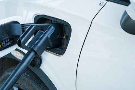 Bangkok, Thailand - January,10, 2024:Power cable is connected to the charger of the electric vehicle close up. Charging an electric car in the parking lotの写真素材