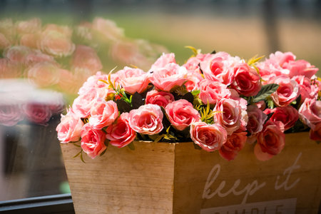 A beautiful display of pink roses in a wooden box, capturing the elegance and freshness of the flowers.の写真素材