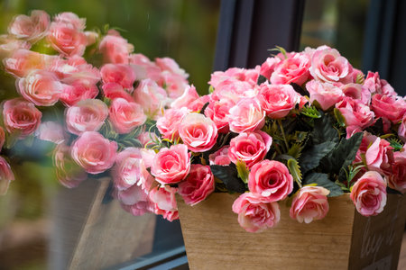 A beautiful display of pink roses in a wooden box, capturing the elegance and freshness of the flowers.の写真素材