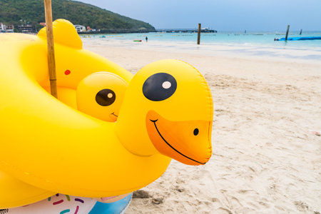 A stack of colorful animal-shaped inflatable floats, including flamingos and unicorns, is ready for fun water activities on the beach.の写真素材