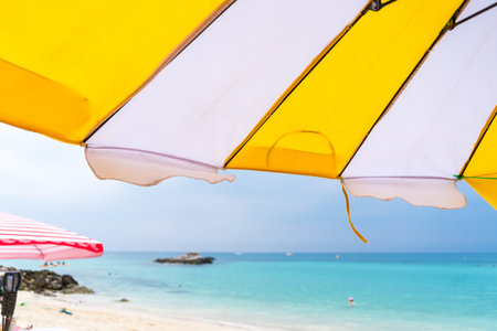 Relax under vibrant beach umbrellas on a peaceful beach, perfect for summer and holiday imagery.の写真素材