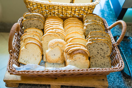 A close-up of a wicker basket filled with freshly baked sliced bread, showcasing different textures and colors.の写真素材