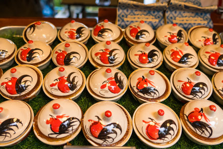 Rooster-decorated bowls filled with Thai sweets, enhancing the vibrant atmosphere of traditional Thai markets.の写真素材