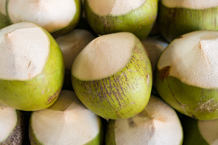Fresh green coconuts with tops cut off, ready for enjoying fresh coconut water.の写真素材
