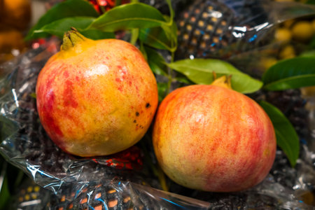 An inviting display of fresh pomegranates laid out in a bustling fruit market, showcasing their rich red color and health benefits, enticing shoppers to enjoy this delicious superfood.の写真素材