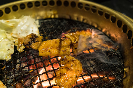 A delicious Korean BBQ setup featuring grilled pork, vegetables, and melted cheese.の写真素材