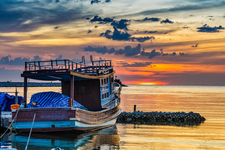 A breathtaking coastal sunset scene featuring rocky shores, tranquil waters, and vibrant skies.の写真素材