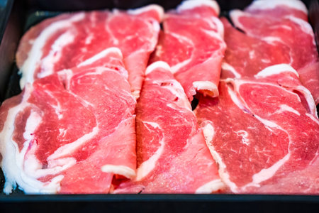 Fresh beef slices with intricate marbling of fat, showcasing tenderness and juiciness, perfect for gourmet dishes or hotpot.の写真素材