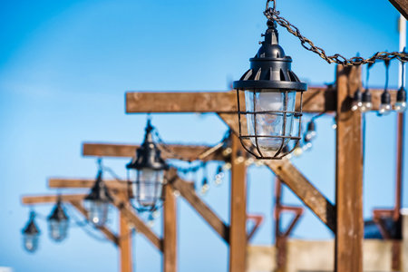 Beautiful lanterns adorning wooden structures, perfect for enhancing the aesthetics of your outdoor space.の写真素材