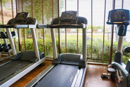 Chonburi, Thailand - November, 18, 2024: Spacious Fitness Room with Large Windows, Mirrors, and a Variety of Exercise Equipment at Chonburi, Thailand.のeditorial素材
