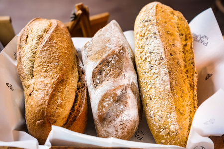 A basket filled with a variety of freshly baked bread, perfect for any meal.の写真素材