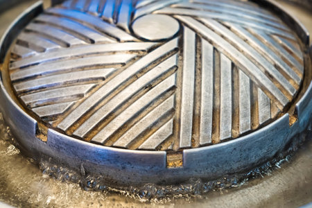 Circular Korean BBQ Grill Made of Stainless Steel with Distinctive Engraved Designの写真素材