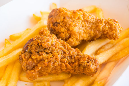 Hot and Spicy Fried Chicken Legs Paired with Crispy Golden Fries for a Perfect Fast Food Treatの写真素材