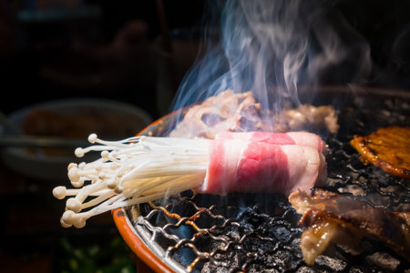 Tasty Enoki Mushrooms Wrapped in Bacon, Grilling on a Smoky BBQ for a Delicious Mealの写真素材