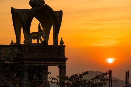 Phetchabun, Thailand - January, 06, 2025 : Stunning Thai Temple Illuminated by Sunrise with Scenic Mountain Backdrop at Phetchabun, Thailand.の写真素材