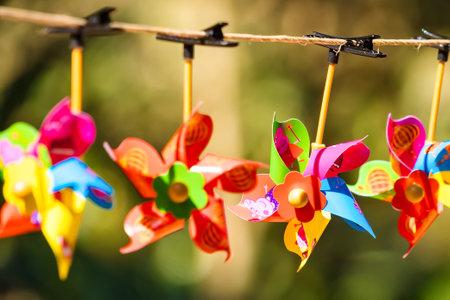 Decorative Pinwheels Hanging on a String: A Playful and Festive Display in a Sunny Garden Settingの写真素材