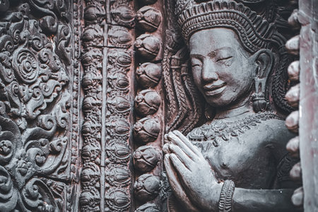 Lop Buri, Thailand - January, 02, 2025 :Ancient stone carvings of Apsara dancers with intricate details and ornate patterns on temple walls at Lop Buri, Thailand.の写真素材