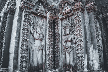 Lop Buri, Thailand - January, 02, 2025 :Ancient stone carvings of Apsara dancers with intricate details and ornate patterns on temple walls at Lop Buri, Thailand.の写真素材