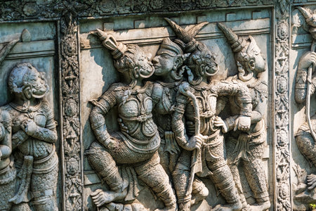 Ayutthaya, Thailand - March, 10, 2025 : Intricate ancient stone carving depicting a warrior with a...