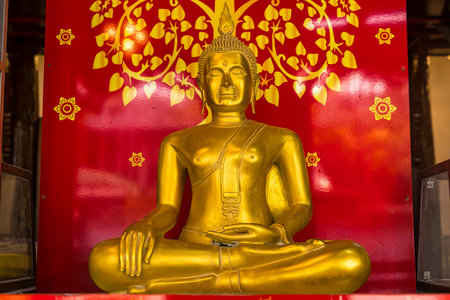 Ayutthaya, Thailand - March, 10, 2025 : A golden Buddha statue sits serenely on an intricately decorated pedestal in a beautifully ornate shrine room at Ayutthaya, Thailandの写真素材