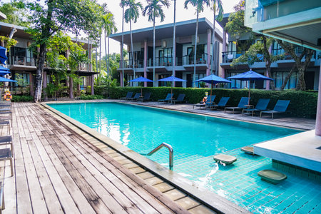Rayong, Thailand - April, 01, 2025 :Luxury outdoor swimming pool surrounded by modern resort...