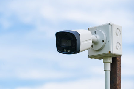 Outdoor security camera mounted on a wooden post with a blurred background