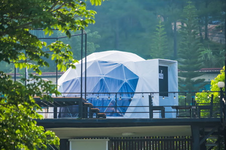 Phetchabun, Thailand - June, 06, 2025 :Scenic view of modern geodesic dome tents in an eco-resort nestled in lush green hills under a blue sky with scattered clouds at Phetchabun, Thailandの写真素材