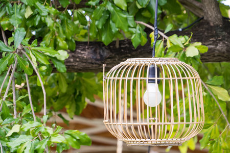 Two bamboo lanterns hanging outdoors with a lush green mountainous backdrop creating a serene and natural ambianceの写真素材