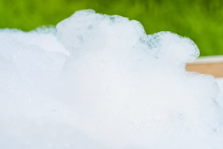Close-up of frothy soap bubbles forming a foamy texture against a white background.の写真素材