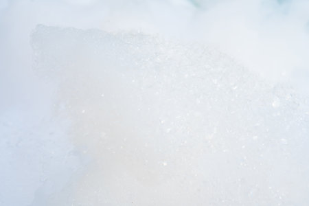 Close-up of frothy soap bubbles forming a foamy texture against a white background.の写真素材
