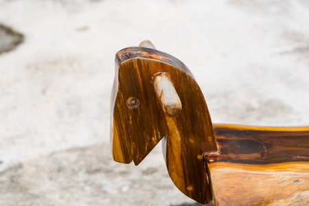 Handcrafted wooden rocking horse displayed with a sandy backgroundの写真素材