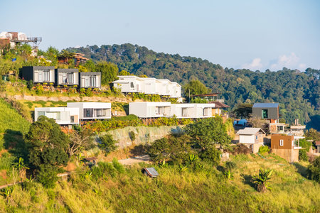 Chiang Mai, Thailand - January, 06, 2026 :Charming homes nestled into the side of a lush mountain,...