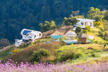 Chiang Mai, Thailand - January, 06, 2026 :Charming homes nestled into the side of a lush mountain, blending seamlessly with the vibrant green environment. Offering a serene view of nature at Chiang Mai Thailand.の写真素材