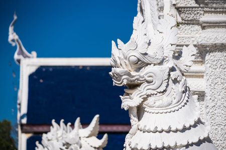 Chiang Mai, Thailand - January, 06, 2026 : Mystical Guardian: A detailed perspective of a guardian statue, positioned in front of a temple, capturing the essence of cultural heritage and architectural artistry.の写真素材