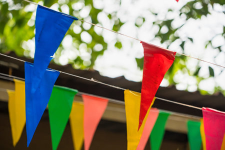 Colourful flags hanging on rope in the garden, stock photo