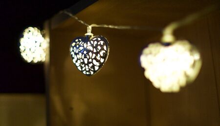 Heart shaped night lights, hanging from a shelf.の写真素材