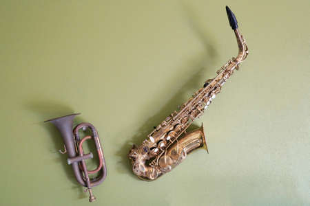 Trumpet with saxophone on green concrete wall., Thailandの写真素材