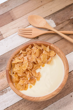 Yogurt and cereal flakes on bowl wood with breakfastの写真素材