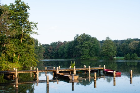 Jetty with rowing boats at the first rays of sunshine. Location: Germany, North Rhine Westphalia, Hoxfeldの写真素材