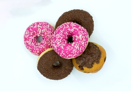 Pink and chocolate donuts and muffin isolated on white. Studio shot on white backgroundの写真素材