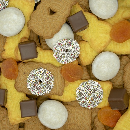 square Christmas background made of different sorts of Christmas cookies, dominoes and dried apricotsView from aboveの写真素材