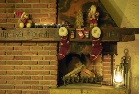Rustic fireplace with Christmas decorations, Christmas stockings and kerosene lamp.の写真素材