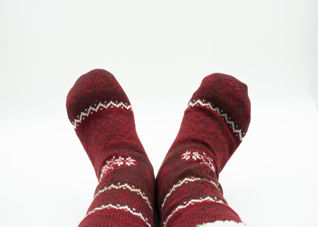 Feet with christmas socks isolated on whiteの写真素材