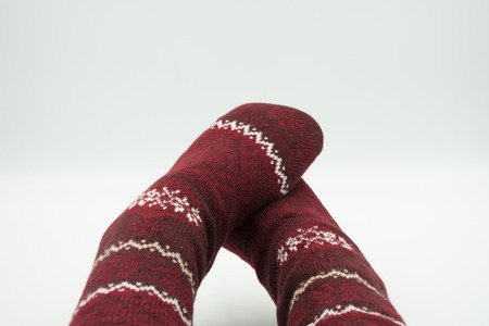 Feet in cozy Christmas socks isolated on whiteの写真素材