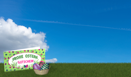Gift card and easter basket on green meadow with blue sky. With text in german: Happy Easter and voucher. 3d renderingの写真素材