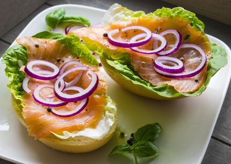 smoked salmon with lettuce and red onions on fresh breadの写真素材